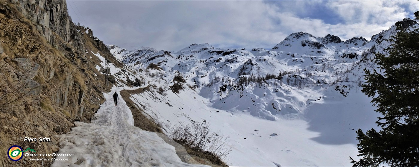 31 Risaliti sull'alto della diga proseguiamo con accanto l'invaso vuoto ricoperto di neve .jpg